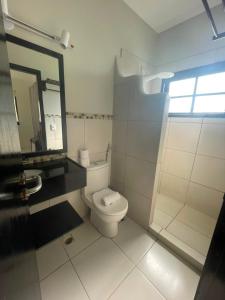 a white bathroom with a toilet and a mirror at Villa Veríssimo in Jericoacoara