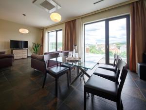 a living room with a glass table and chairs at Rezidence Fontána in Teplice