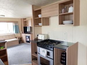 a kitchen with a stove top oven in a room at Elli-Roo's cabin in Hartley