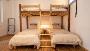 two bunk beds in a room with wooden floors at Gîte de l 'Annonciation in Lourdes