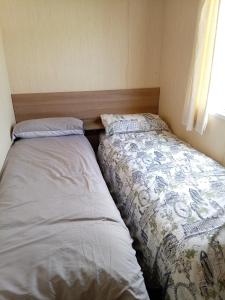 two beds sitting next to each other in a bedroom at Elli-Roo's cabin in Hartley
