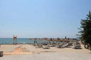 una spiaggia con sedie e ombrelloni e l'oceano di Villa Allegra a Kavarna