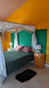 a bedroom with a bed with a green and yellow wall at Tsanta lodge in Talata-maty
