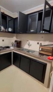 a kitchen with black cabinets and a sink at naderi in Tangier