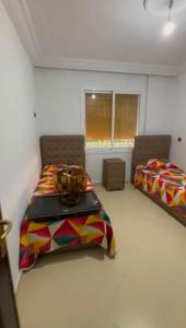 a bedroom with two beds and two windows at naderi in Tangier