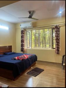a bedroom with a large bed and a window at Stay in Forest in Haldwāni