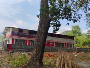 a building with a tree in front of it at Stay in Forest in Haldwāni