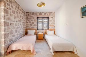 two beds in a room with a brick wall at Rustic Stone House with Spacious Terrace 2BR in Burhaniye