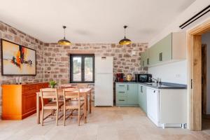 a kitchen with a table and chairs and a brick wall at Rustic Stone House with Spacious Terrace 2BR in Burhaniye