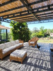 a patio with a couch and two chairs and a table at Rustic Stone House with Spacious Terrace 2BR in Burhaniye