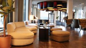 a lobby with couches and a table and chairs at Solo Sokos Hotel Paviljonki in Jyväskylä