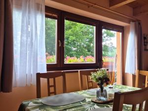 a table with a vase of flowers and a window at Apartmán Donovaly Mišuty 586 in Donovaly +27 photos