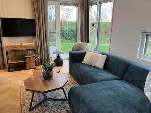 a living room with a blue couch and a table at Resort Kagerplassen in Warmond
