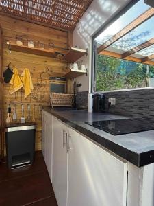 a kitchen with white cabinets and a large window at Ô Pationato in Saint-Louis