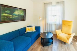 a living room with a blue couch and a chair at Das Schneckenhaus EG in Lathen