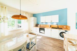 a kitchen with white cabinets and a table with chairs at Das Schneckenhaus EG in Lathen
