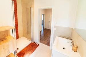 a bathroom with a shower and a white sink at Das Schneckenhaus EG in Lathen