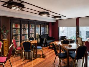 a dining room with tables and chairs and bookshelves at Hotel Sancho Abarca Petit SPA in Huesca