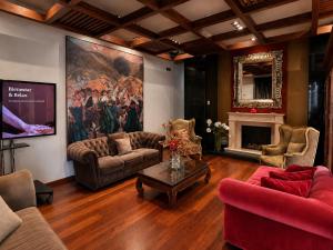 a living room with couches and a painting on the wall at Hotel Sancho Abarca Petit SPA in Huesca