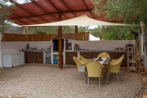 a patio with a table and chairs under an umbrella at Can Mimosa Guesthouse in Tortosa