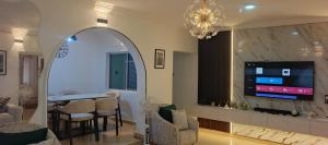 ein Wohnzimmer mit Fernseher, Tisch und Stühlen in der Unterkunft Harlington Duplex in Akitan