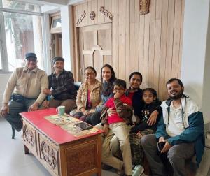 a group of people posing for a picture in a room at Norbu Homestay in Darjeeling