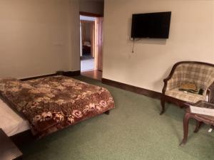 a bedroom with a bed and a chair and a flat screen tv at Multiple Hotels in Malam Jabba Swat in Malam Jabba