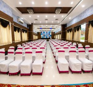 a conference hall with white chairs in the middle at Hotel Rockfort View by Park Elanza in Tiruchirappalli