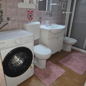 a bathroom with a washer and a toilet and a sink at Apartman Hersek Mostar in Mostar +36 photos
