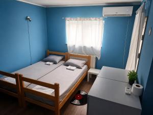 a small room with two beds and a blue wall at Hostel Bed&Coffee 360° in Belgrade