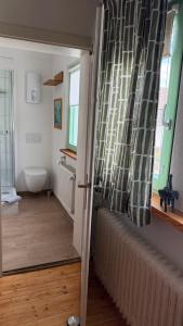a hallway with a bathroom with a radiator and a window at Ferienwohnung Eule in Kastellaun +17 photos
