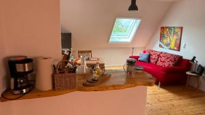 a living room with a red couch and a wooden table at Ferienwohnung Eule in Kastellaun