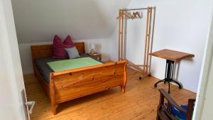 a bedroom with a wooden bed and a table at Ferienwohnung Eule in Kastellaun