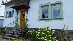 a blue house with a staircase and a window at Ferienwohnung Eule in Kastellaun