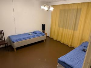 a room with two beds and a television in it at LibO-apartment Porokylä 14 in Porokylä