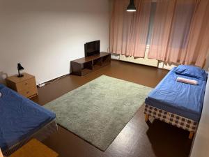 a room with two beds and a television in it at LibO-apartment Porokylä 14 in Porokylä