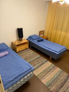 a room with two beds and a tv on a table at LibO-apartment Porokylä 14 in Porokylä