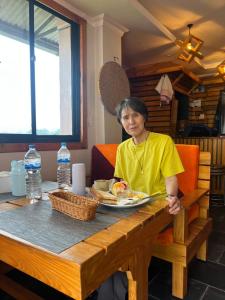 a woman sitting at a table with a plate of food at Bandipur Samira Hotel & Homestay - your comfort in heart of Bandipur in Bandipur +98 photos