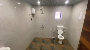 a bathroom with a toilet and a phone on the wall at The Byke Retreat - Laxmi Resort - Pan India Pure Veg Hotel Chain in Matheran