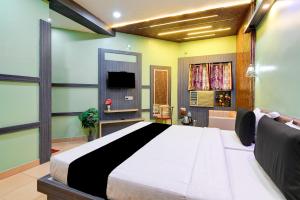 a bedroom with a large bed and a tv at Hotel Shree Krishna in Keonjhargarh