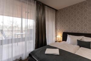 a bedroom with a bed and a large window at Hotel Anna Mátrafüred in Mátrafüred +56 photos