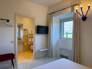 a bedroom with a bed and a window and a bathroom at franciacorta iseo lake house in Clusane sul Lago
