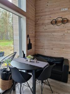 a dining room with a black table and chairs at Liedaga namiņš in Mērsrags