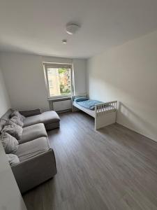 a living room with a couch and a bed at Monteurzimmer Schölerpad 24h Self Check in in Essen