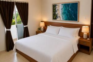 a bedroom with a large white bed and a window at La Costa Playa El Agua Hotel in El Agua +32 photos