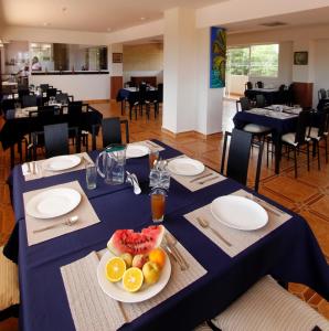 a blue table with a plate of fruit on it at La Costa Playa El Agua Hotel in El Agua