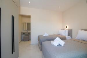 a hotel room with two beds with white towels on them at Glamour Residences 5-6 by CorfuEscapes in Análipsis