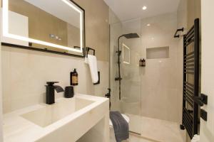 a white bathroom with a sink and a shower at Glamour Residences 5-6 by CorfuEscapes in Análipsis +7 photos