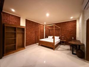 a bedroom with a bed and a brick wall at Mu Homestay Tetebatu in Tetebatu +186 photos