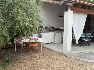 a table and chairs in a backyard with a kitchen at Location Vacances à Laudun in Laudun